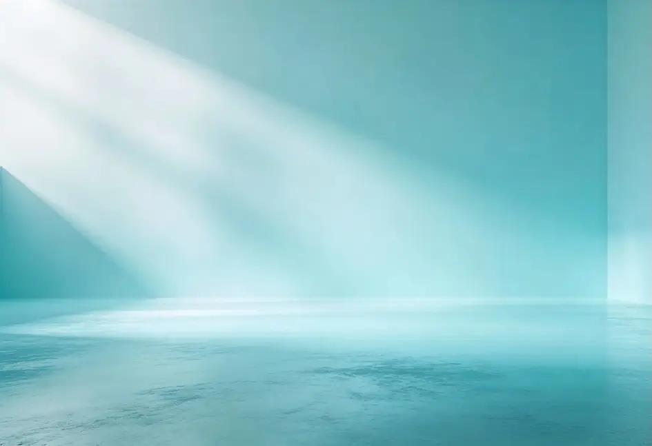 Habitación vacía de color azul claro con suelo y paredes lisos, iluminada por la luz solar diagonal que entra por la parte superior izquierda, creando un suave degradado de luces y sombras.